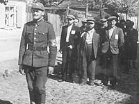 Литовский полицай конвоирует группу евреев, Вильнюс, 1941 год Литовский полицай конвоирует группу евреев, Вильнюс, 1941 год