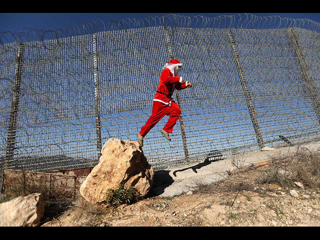 У забора безопасности во время антиизраильской акции протеста в Вифлееме 23 декабря 2019 года