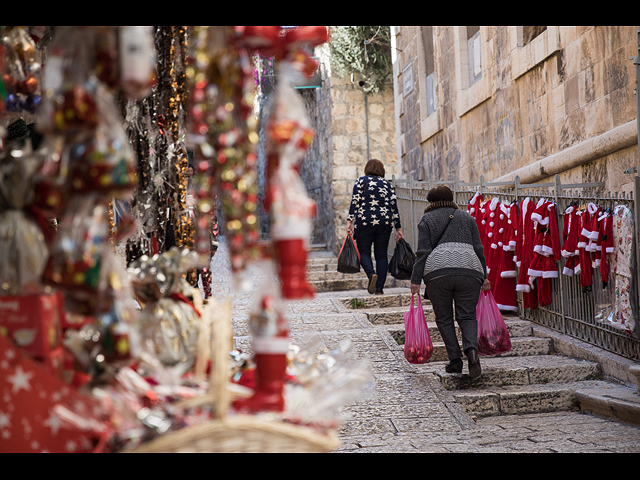 Люди у магазина, продающего рождественские украшения, в христианском квартале Старого города Иерусалима, в преддверии Рождества, 19 декабря 2019 года