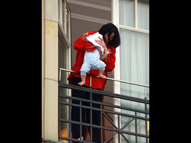 Майкл Джексон держит своего восьмимесячного сына Принца Майкла II на балконе отеля Adlon 19 ноября 2002 года в Берлине, Германия