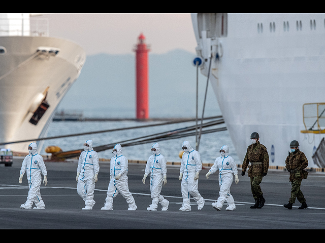 Японские солдаты и сотрудники экстренных служб в защитной одежде выходят из круизного лайнера Diamond Princess, где они пополняли запасы и диагностировали новые случаи заражения коронавирусом. 10 февраля 2020 года, Иокогама, Япония