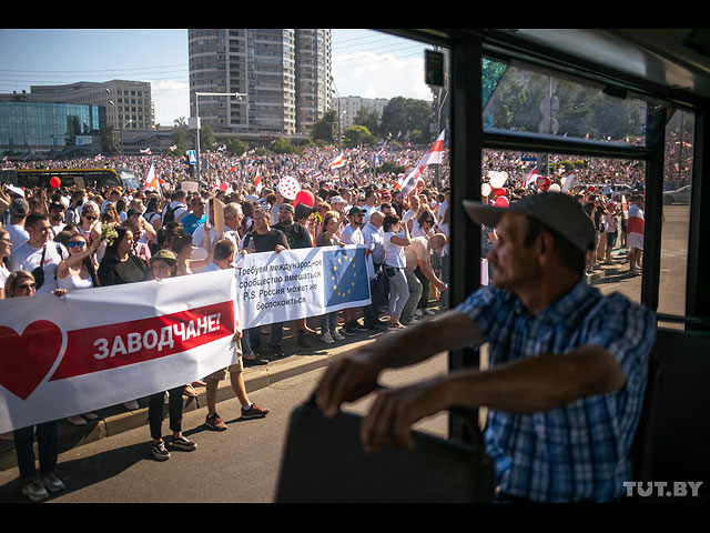 Мужчина проезжает мимо стелы в разгар митинга