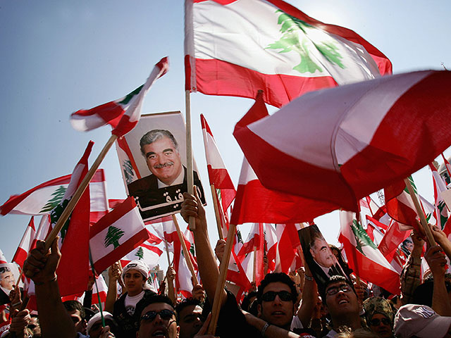 Протестующие с транспарантами и флагами спустя один месяц после убийства Харири на площади Мучеников 14 марта 2005 года в Бейруте, Ливан