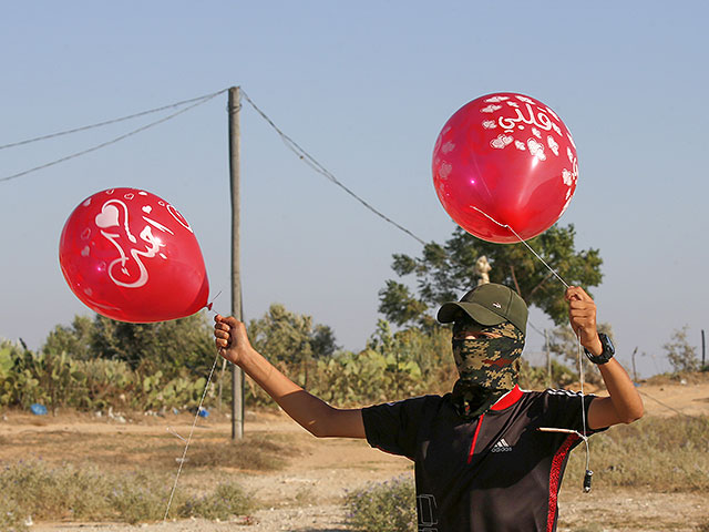 Подросток из Газы готовится запустить воздушные шары со взрывными и зажигательными устройствами в направлении израильской границы.  21 августа 2020 года