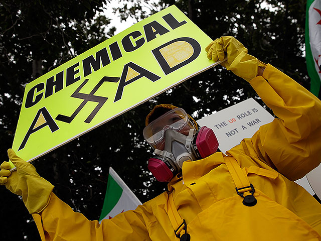 Демонстрант с сирийскими корнями призывает к нанесению удара по Сирии за использование химического оружия против собственного народа. 9 сентября 2013 года, Вашингтон