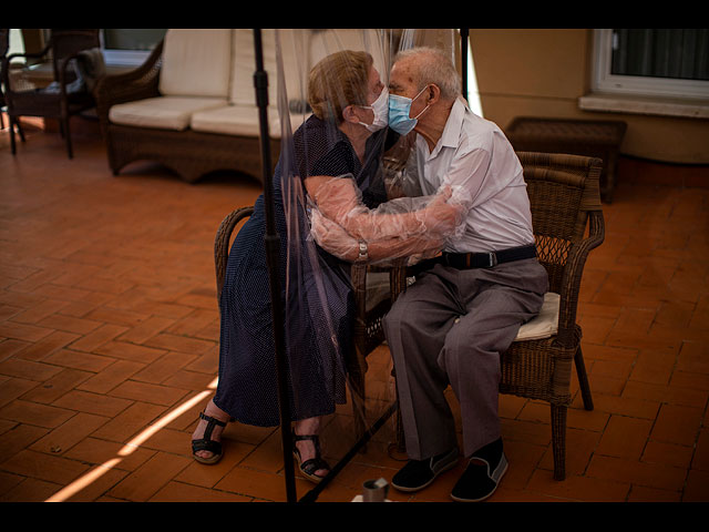 Агустина Каньямеро, 81 год, и Паскаль Перес, 84 года, обнимаются через полиэтиленовую пленку, чтобы избежать заражения коронавирусом в доме престарелых в Барселоне, Испания
