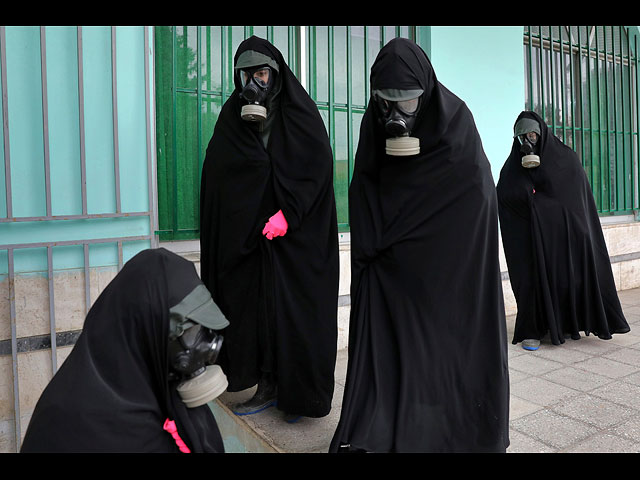 Женщины-священнослужители в защитной одежде и чадре прибывают на кладбище, чтобы подготовить тело человека, умершего от COVID-19, к похоронам. Иран, 30 апреля 2020 года