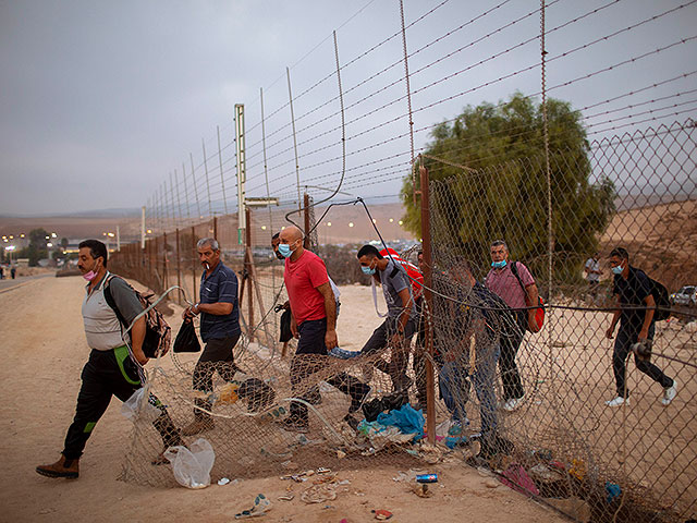 Палестинские рабочие незаконно переходят в Израиль через отверстие в заборе к югу от города Хеврон на Западном берегу