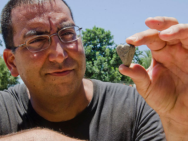 Археолог Саар Ганор с находкой, обнаруженной при раскопках базилики в национальном парке Тель-Ашкелон