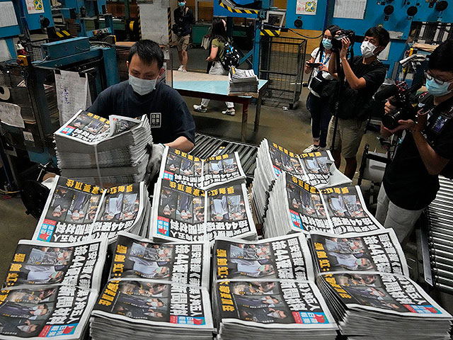 Рабочий в типографии упаковывает один из последних тиражей газеты Apple Daily. Гонконг, 18 июня 2021 года