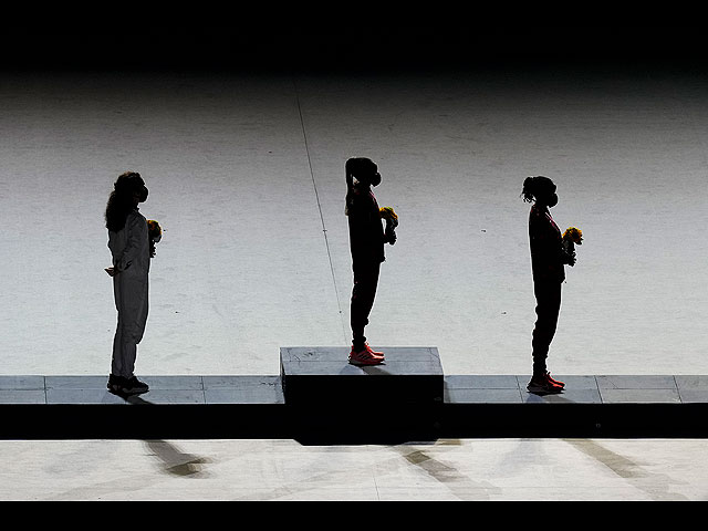 Слева направо: серебряный призер Бригид Косгей (Кения), золотой призер Перес Джепчирчир (Кения) и бронзовый призер Молли Зайдель (США) на пьедестале почета после вручения медалей в женском марафоне во время церемонии закрытия Олимпиады
