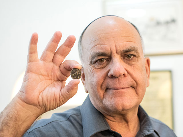 Директор Управления древностей Эли Эскозидо с монетой, которая отправится с израильтянином в космос
