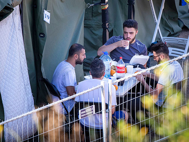 Мигранты ужинают в недавно построенном лагере для беженцев в городе Пабраде, примерно в 40 км к северо-востоку от Вильнюса, Литва, 3 июля 2021 года