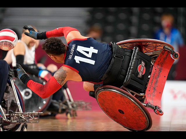 Джозеф Делагрейв из США теряет равновесие во время матча за золотую медаль по регби на инвалидных колясках