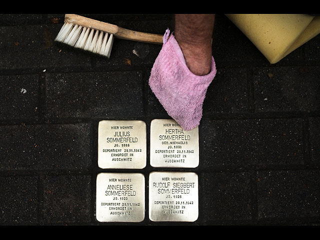 Берлинец Йорг Либих полирует "камни преткновения" в память о четырех членах семьи, депортированных и убитых нацистами в Освенциме. Берлин, Германия, 8 ноября 2021 года