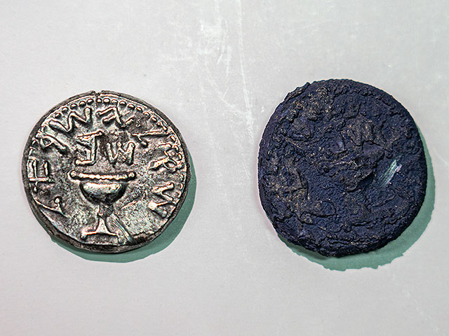 Серебряная монета рядом с обугленной монетой сгоревшей при разрушении Иерусалима