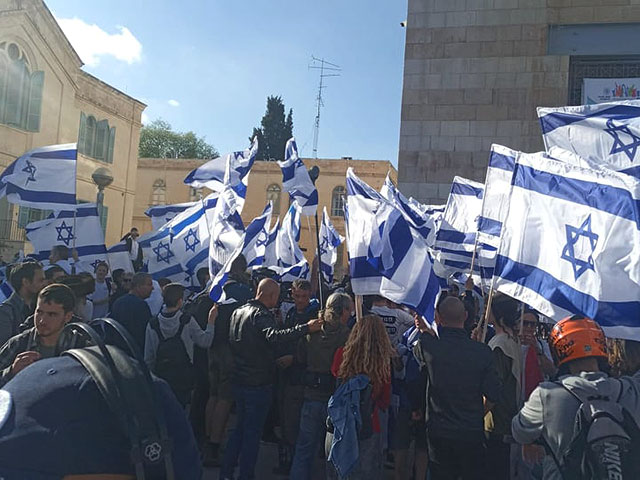 В Иерусалиме десятки правых активистов под флагами Израиля направляются к Шхемским воротам. 20 апреля 2022 года
