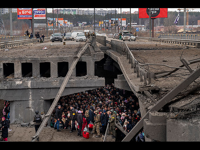 Жители Киева толпятся под разрушенным мостом, пытаясь бежать через реку Ирпень на окраине Киева, Украина, 5 марта 2022 года