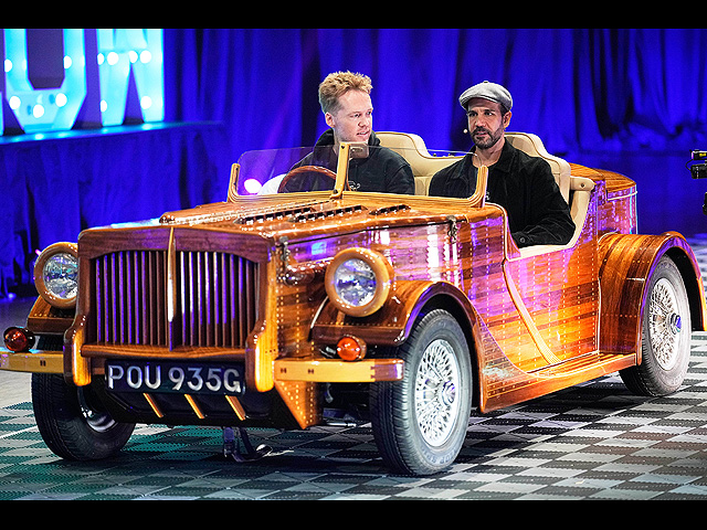 Люди сидят в изготовленном на заказ историческом британском автомобиле с шасси из красного дерева в форме лодки Riva 1969. Эссен, Германия