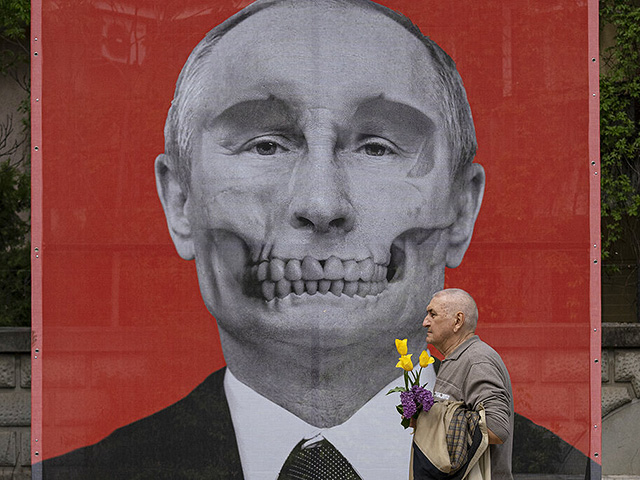 Мужчина проходит мимо изображения Владимира Путина работы Крисса Салманиса, Латвия