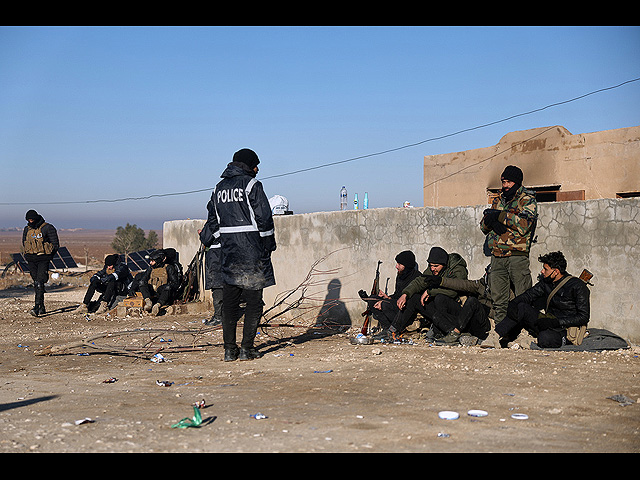 Сирийские правительственные войска со своим багажом ожидают входа в лагерь аль-Холь в провинции аль-Хасаке на северо-востоке Сирии