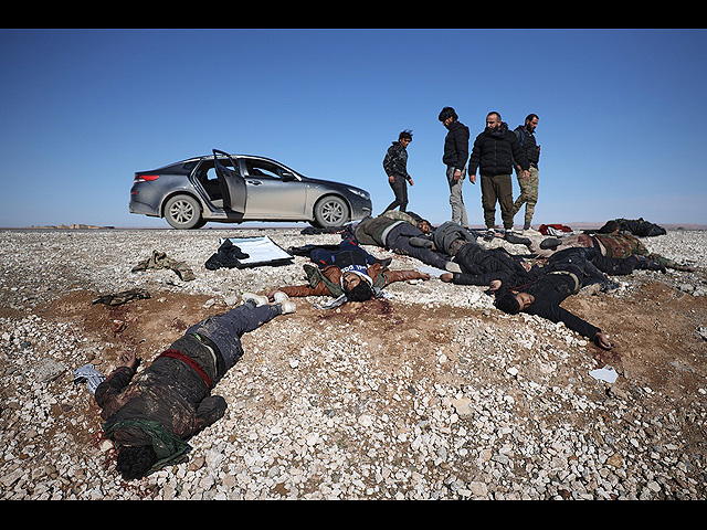 Ополченцы союзные сирийскому правительству осматривают тела отступающих бойцов "Сирийских демократических сил"