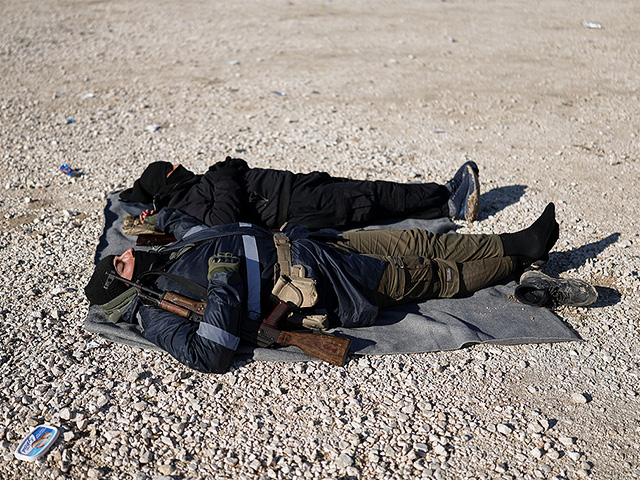 Бойцы сирийских правительственных сил спят на земле, ожидая возможности войти в лагерь Аль-Холь