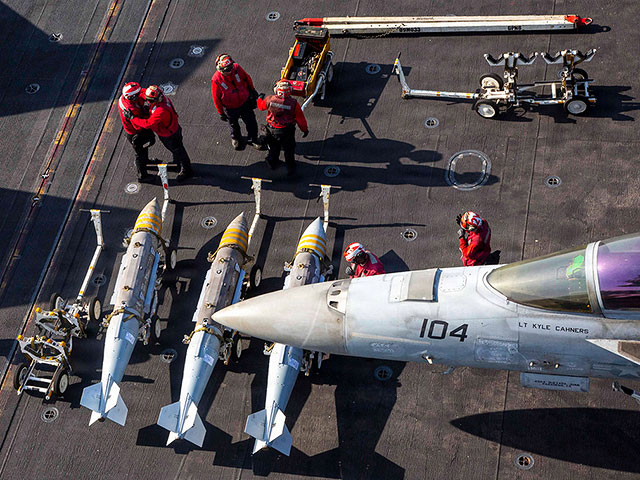 Моряки ВМС США готовят к погрузке боеприпасы на истребитель F/A-18F Super Hornet на борту авианосца USS Abraham Lincoln в рамках операции «Эпическая ярость»