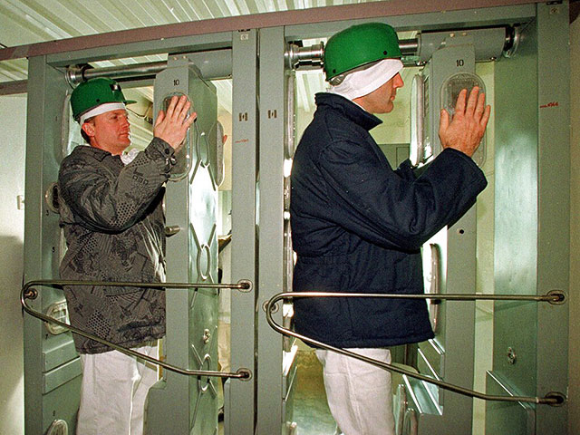 Рабочие ЧАЭС проверяют уровень радиации после выхода из саркофага, 10 ноября 2000 года. При обнаружении радиоактивных частиц аппараты не пропускают людей; им приходится возвращаться и снова очищаться