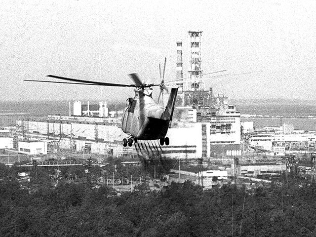 Вертолет, сбрасывающий реагенты для снижения уровня радиации, приближается к четвертому разрушенному реактору Чернобыльской АЭС. 12 мая 1986 года. 