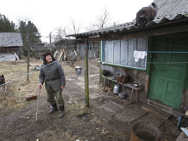 Иван Шамянок во дворе своего дома в почти заброшенной деревне Тульговичи, расположенной недалеко от 30-километровой зоны отчуждения вокруг Чернобыльской АЭС. 2011 год