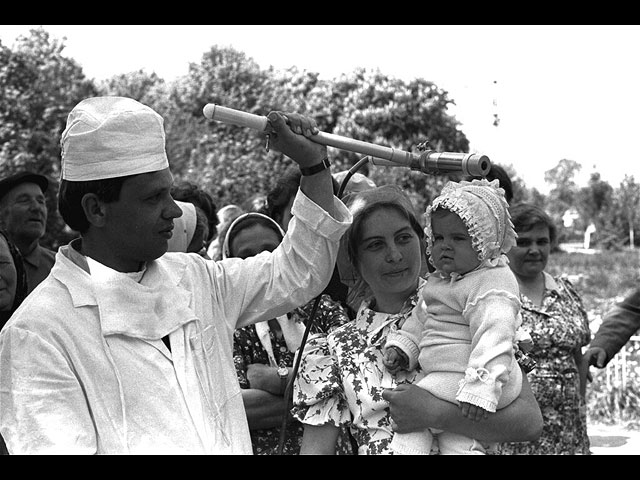 Дозиметрист осматривает маленькую Катю Литвинову во время проверки жителей села Копылово под Киевом. 9 мая 1986 года