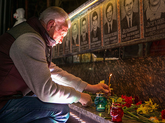 Мужчина зажигает свечу у мемориала, посвященного пожарным и рабочим, погибшим после Чернобыльской ядерной катастрофы 1986 года. Славутич, Украина, 26 апреля 2026 года