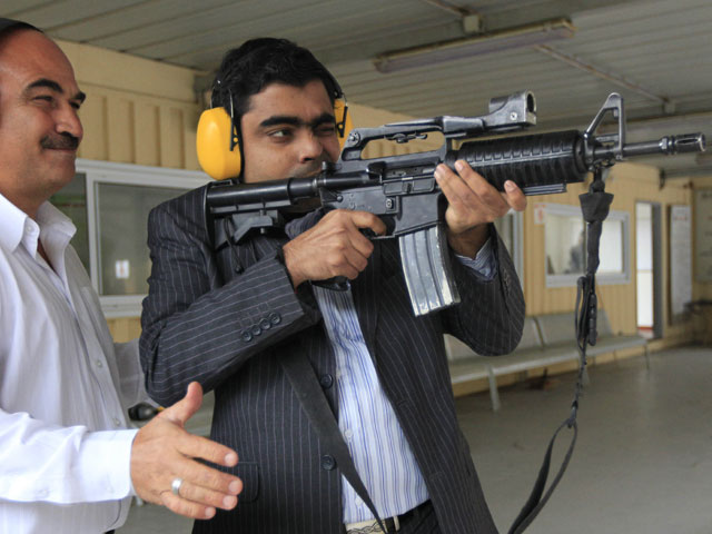 Представитель индийской компании пробует стрелять из усовершенствованного израильскими специалистами автомата M16