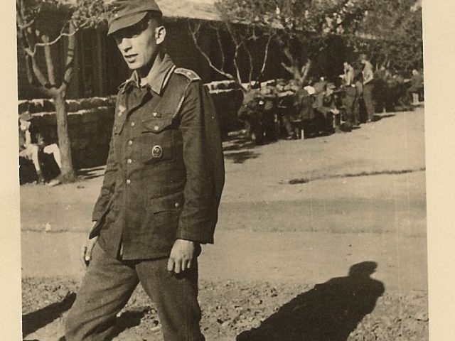 Герхард Курцбах на фоне военных автомастерских в городе Бохня