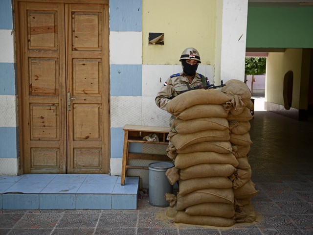 Охрана у входа на избирательный участок в пригороде Каира. 27 мая 2014 г.