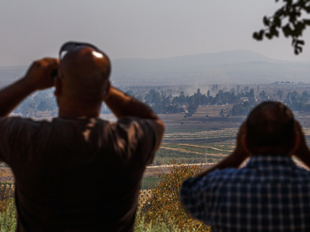 Израильтяне наблюдают за боем на территории Сирии в районе Кунейтра