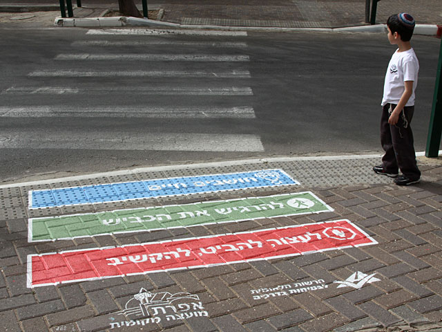 Пешеходный переход с лозунгами, призывающими к осторожности при пересечении дороги, недалеко от школы в Эфрате