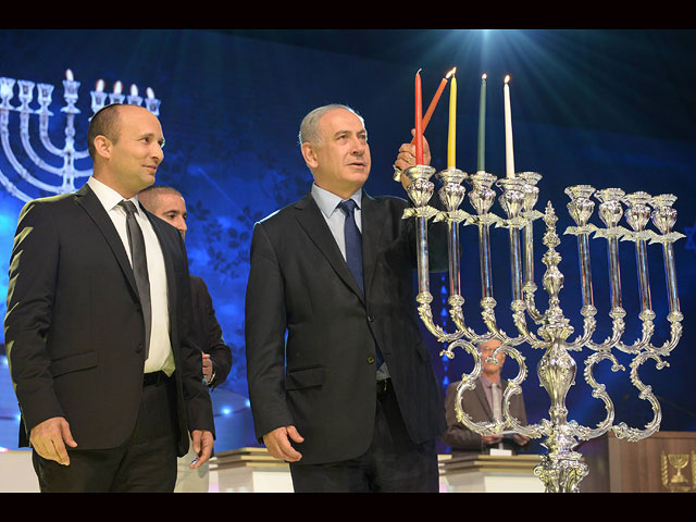 Премьер-министр Израиля Биньямин Нетаньягу и министр образования Нафтали Беннет зажигают ханукальные свечи на Национальном конкурсе Библии для взрослых в Иерусалиме. 9 декабря 2015