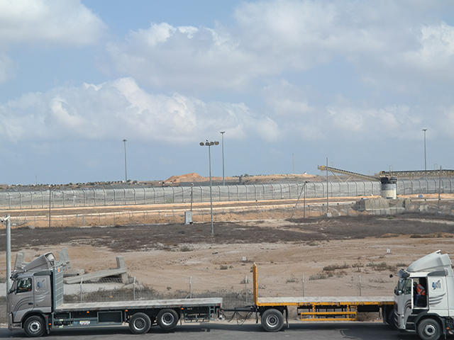 На заднем плане - горы песка, которые видны с израильской стороны КПП "Керем Шалом"