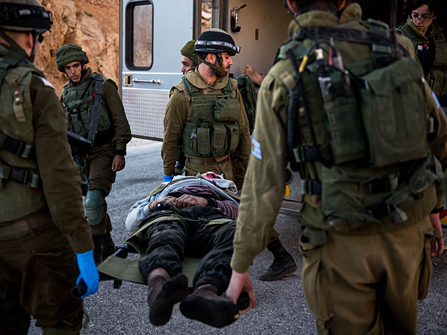 Израильские военнослужащие эвакуируют раненого из сирийской деревни