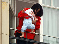 Майкл Джексон держит своего восьмимесячного сына Принца Майкла II на балконе отеля Adlon 19 ноября 2002 года в Берлине, Германия