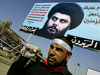 Иракский шиит несет транспарант с портретом Муктада ас-Садра