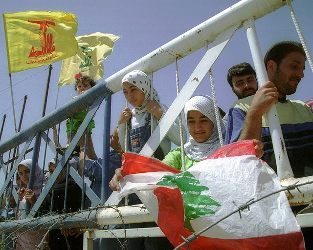 Ливанцы с флагами Хизбаллы на израильско-ливанской границе к западу от Метулы, 25 мая 2000 года