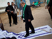 Аз-Захар топчет флаг Израиля, на котором на арабском языке написано: "Израиль несомненно будет уничтожен"