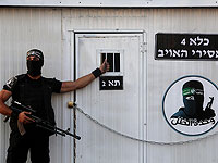 Боевик военного крыла ХАМАС, "охраняет" макет тюрьмы для израильских солдат во время митинга в лагере беженцев Рафах