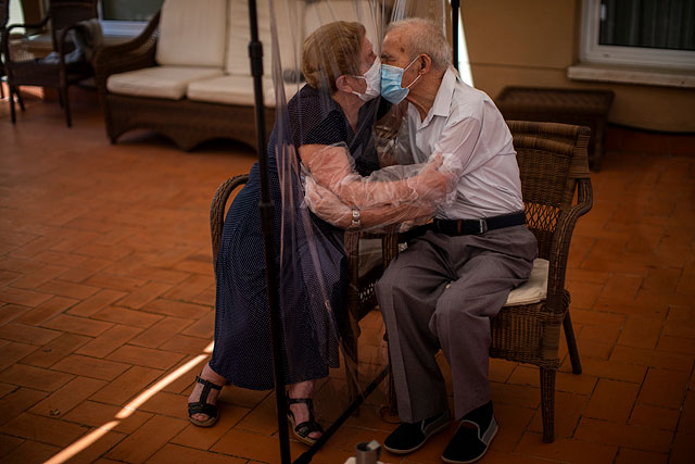 Агустина Каньямеро, 81 год, и Паскаль Перес, 84 года, обнимаются через полиэтиленовую пленку, чтобы избежать заражения коронавирусом в доме престарелых в Барселоне, Испания