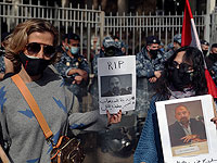 Протестующие против "Хизболлы" держат фотографии Локмана Слима. Надпись на плакате гласит: "Террористическое государство: взрывы, похищения, убийства". Бейрут, Ливан, 4 февраля 2021 года