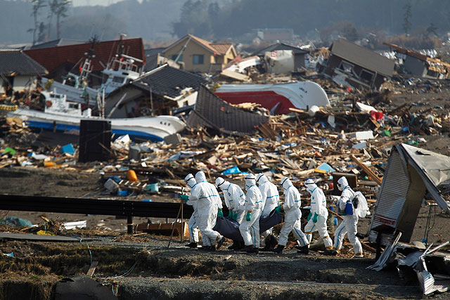 Полицейские несут тело найденное в районе, разрушенном землетрясением и цунами 11 марта. Намие, префектура Фукусима, северо-восток Японии, 15 апреля 2011 года