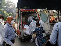 Медицинские работники выгружают тела шести человек, умерших от COVID-19, для кремации в Нью-Дели, Индия. Апрель 2021 года